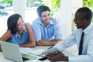 Homebuyer reviewing a closing disclosure beside a calculator and signed real estate documents.